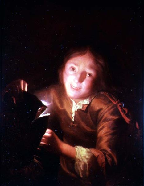 A Young Boy Holding a Candle Behind a Halloween Mask