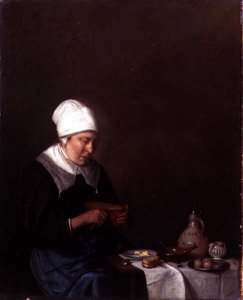 A Woman Seated at a Table Cutting a Slice of Cheese