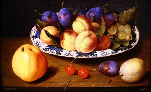 Still life of peaches and plums in a blue and white dish on a table top