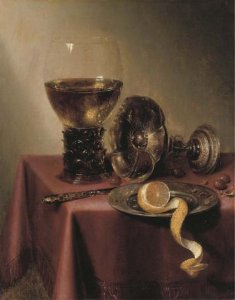 An upturned silver tazza, hazelnuts, a peeled lemon on a pewter platter, a knife and a roemer, on a draped table